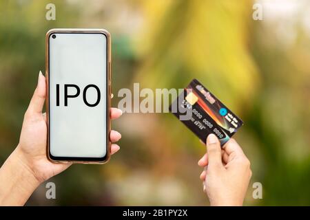 SBI Cards & Payments servizi IPO background. Indian femmina mano che tiene la carta di stato della Banca dell'India ATM per esso è Offerta pubblica Iniziale imminente. Foto Stock