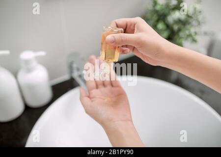 Le mani umane usano un gel, un disinfettante, un antisettico in una bolla, un vasetto Foto Stock