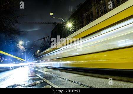 Berlino, Germania. 26th Feb, 2020. Oranienburger Strasse A Berlino-Mitte. Le luci di un tram che passa e le auto passano spiccano come strisce luminose e sono riflesse dalla strada bagnata. Sullo sfondo è possibile vedere la torre della televisione. Effetto di pulizia a causa di un tempo di esposizione più lungo. Credito: Gerald Matzka/dpa-Zentralbild/ZB/dpa/Alamy Live News Foto Stock