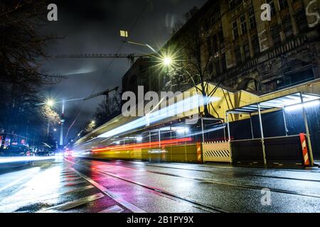 Berlino, Germania. 26th Feb, 2020. Oranienburger Strasse A Berlino-Mitte. Le luci di un tram che passa e le auto passano spiccano come strisce luminose e sono riflesse dalla strada bagnata. Sullo sfondo è possibile vedere la torre della televisione. Effetto di pulizia a causa di un tempo di esposizione più lungo. Credito: Gerald Matzka/dpa-Zentralbild/ZB/dpa/Alamy Live News Foto Stock