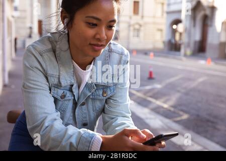 Donna che usa il telefono per strada Foto Stock