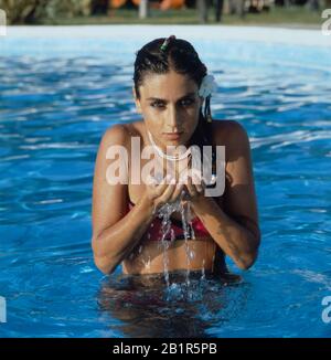 Homerory der italienisch amerikanischen Sängerin und Schauspielerin Romina Power hier mit Bikini im Pool, mitte 1980er Jahre. Home storia della cantante e attrice italo-americana Romina Power qui con bikini in piscina, metà 1980s Foto Stock