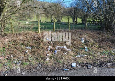 Rifiuti e rifiuti scartati in un layby su una strada rurale in Galles Foto Stock