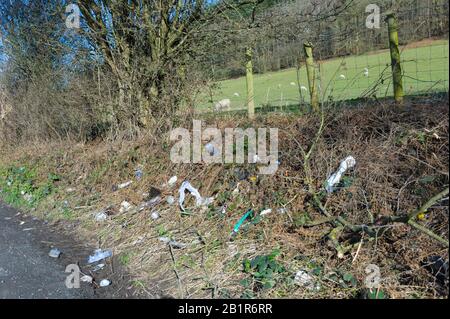 Rifiuti e rifiuti scartati in un layby su una strada rurale in Galles Foto Stock