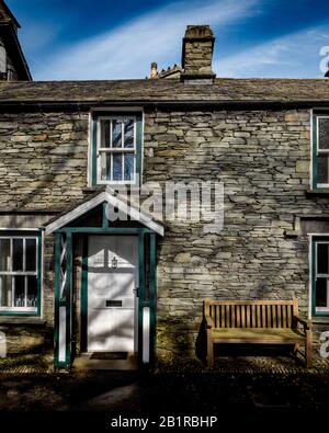 Tradizionali cottage in mattoni di ardesia nella rurale inglese Lake District città di Grasmere conosciuta come la casa del poeta William Wordsworth. Foto Stock