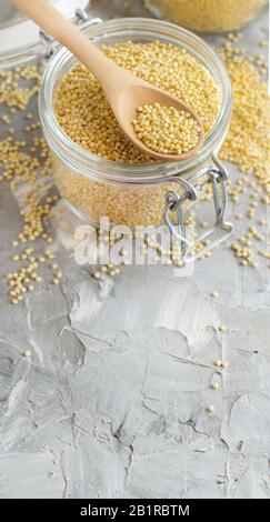 Miglio secco grezzo in un vaso di vetro da vicino Foto Stock