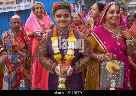 Una madre indù (r), suo figlio e i membri della famiglia sulla loro strada verso un tempio indù che porta offerte sacrificali; Serbatoio di Banganga, Walkeshwar, Mumbai, India Foto Stock