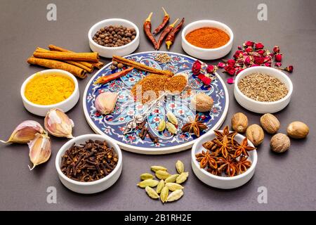 RAS el Hanout, spezia esotica di lusso. Ingredienti per la preparazione di spezie orientali in ciotole di ceramica. Una spezia essenziale per ogni piatto marocchino. Pietra Foto Stock