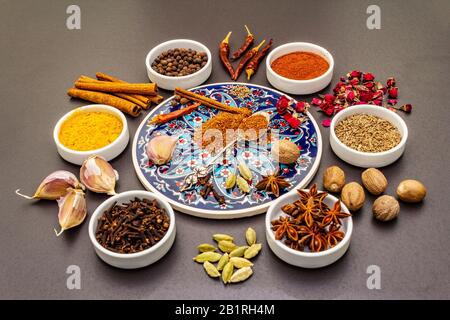 RAS el Hanout, spezia esotica di lusso. Ingredienti per la preparazione di spezie orientali in ciotole di ceramica. Una spezia essenziale per ogni piatto marocchino. Pietra Foto Stock