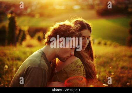 Giovane coppia d'amore che abbraccia un prato, Foto Stock