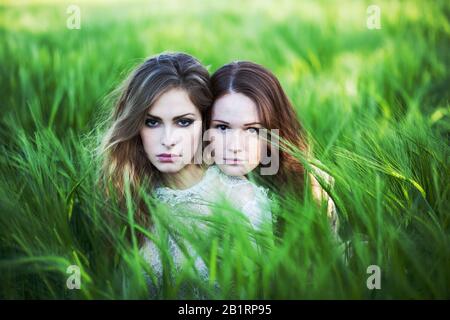 Due donne sono sedute nel campo del grano, Foto Stock