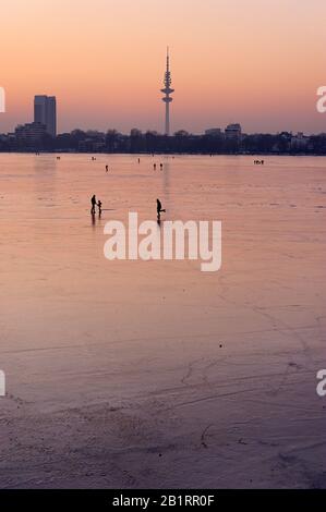 Congelati Außenalster, dopo tramonto, crepuscolo, inverno, Alster piacere, gente, ghiaccio, neve, inverno, Città anseatica di Amburgo, Germania, Foto Stock