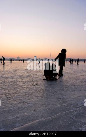 Congelati Außenalster, dopo tramonto, crepuscolo, inverno, Alster piacere, gente, ghiaccio, neve, inverno, Città anseatica di Amburgo, Germania, Foto Stock