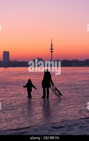 Congelati Außenalster, dopo tramonto, crepuscolo, inverno, Alster piacere, gente, ghiaccio, neve, inverno, Città anseatica di Amburgo, Germania, Foto Stock