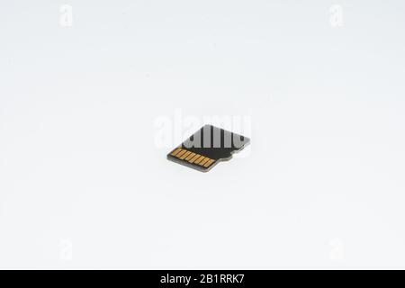 Dettaglio di una piccola memoria di memorizzazione, contatti elettrici visibili, su sfondo bianco Foto Stock
