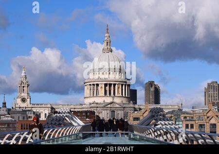 La vista lungo il Millennium Bridge di Londra alla cupola della Cattedrale di St Pauls con un interessante cielo di cielo blu e nuvole con le persone sul ponte Foto Stock