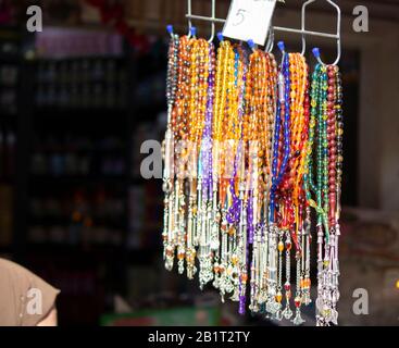 Rosari in diversi colori e dimensioni che sono caduti al suolo. Può essere utilizzato per le esigenze della religione islamica o come accessorio. Foto Stock