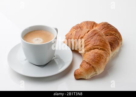Croissant e eine Tasse Kaffee zum Fruehstueck Foto Stock