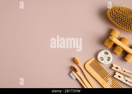 Accessori da bagno ecologici su sfondo marrone. Spazzolini da denti in bambù, pettine per capelli, spazzola per il peeling del bagno, spugna luffa, strumento per massaggi. Bellezza e. Foto Stock
