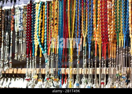 Rosari in diversi colori e dimensioni che sono caduti al suolo. Può essere utilizzato per le esigenze della religione islamica o come accessorio. Foto Stock