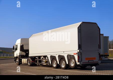 Un camion con un rimorchio specializzato per il trasporto di lastre di cemento e vetro. Foto Stock