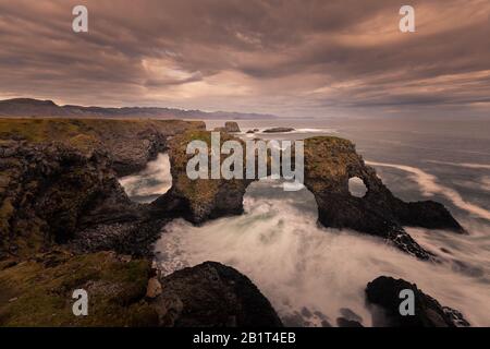 Arco di Gatklettur nella città di Arnarstapi nella penisola di Snæfellsnes, Islanda occidentale. Foto Stock
