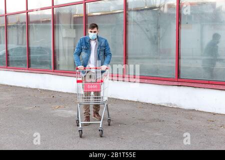 Nessun problema alimentare, panico acquistare cibo. Acquisti nel timore di coronavirus, virus, infezione, epidemia, pandemic.Man in maschera protettiva medica con vuoto Foto Stock