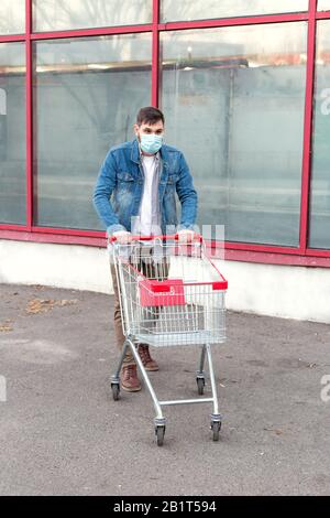 Nessun problema alimentare, panico acquistare cibo. Acquisti nel timore di coronavirus, virus, infezione, epidemia, pandemic.Man in maschera protettiva medica con vuoto Foto Stock