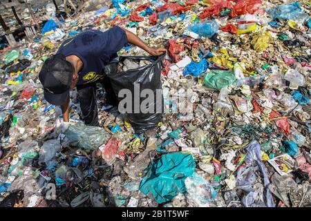 Medan, Sumatra Settentrionale, Indonesia. 27th Feb, 2020. Gli ambientalisti raccolgono rifiuti di plastica nelle baraccopoli di Belawan, a Medan. Centinaia di volontari puliscono mucchi di rifiuti sul lungomare di Belawan, come parte della Giornata Nazionale Per La Cura Dei Rifiuti in Indonesia. Il ministro dell'ambiente e delle foreste del paese ha rivelato che l'Indonesia raggiunge 67 milioni di tonnellate di rifiuti prodotti al giorno. Merito: Albert Ivan Damanik/Zuma Wire/Alamy Live News Foto Stock