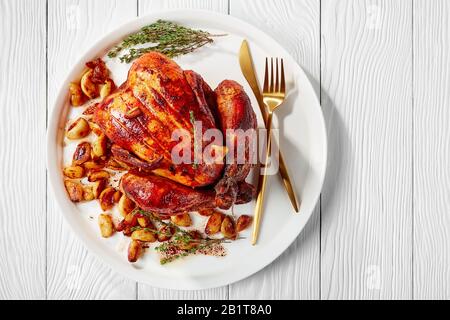 40 spicchi di pollo in un piatto bianco su un tavolo di legno, cucina francese, vista orizzontale dall'alto, piatto, primo piano, spazio libero Foto Stock