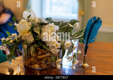una scritta blu quill su un tavolo accanto ai fiori in una cerimonia nuziale Foto Stock