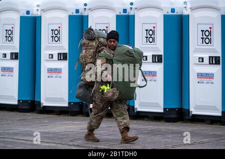 Hagenow, Germania. 27th Feb, 2020. Uno dei primi 120 soldati statunitensi sta portando la sua attrezzatura alle caserme Ernst Moritz Arndt dell'esercito tedesco per il convoglio dei veicoli che si sta recando nel grande esercizio NATO "Defender Europe 2020". Dopo aver trascorso la notte e il rifornimento e la manutenzione dei loro veicoli, il convoglio continuerà il suo viaggio verso est in serata. Nei prossimi giorni sono previsti altri trasporti statunitensi, per un totale di 1.700 soldati statunitensi che dovrebbero attraversare il Meclemburgo-Pomerania occidentale entro il 6 marzo. Credito: Jens Büttner/Dpa-Zentralbild/Dpa/Alamy Live News Foto Stock