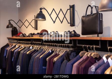 Vestiti colorati maschio, vestiti femmina, scarpe in boutique appesi su appendiabiti, appendiabiti. Concept aprire negozio di lusso, centro commerciale, vendita negozio, re Foto Stock