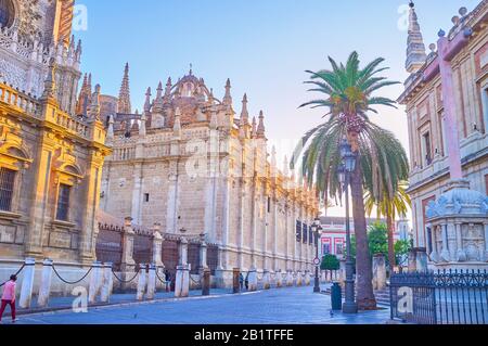 Siviglia, SPAGNA - 1 OTTOBRE 2019: La passeggiata lungo le grandi mura della cattedrale con incredibili decorazioni in stile gotico, il 1° ottobre a Siviglia Foto Stock