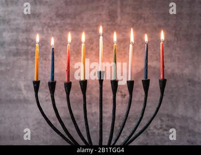 Primo piano di candele accese su un menorah per le celebrazioni Hanukkah. Foto Stock