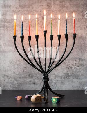 Menorah con candele e sognanti accesi su tavolo nero per Hanukkah. Foto Stock