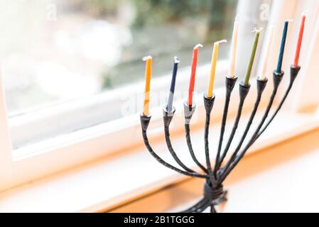 Menorah con candele silluminate per celebrazioni Hanukkah in una finestra. Foto Stock