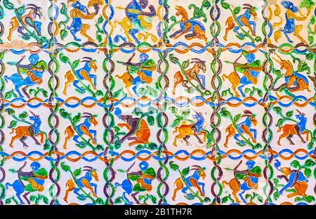 Le storiche piastrelle smaltate in ceramica colorata (Azulejos) con i rilievi mitologici delle creature sulle pareti dei Giardini Alcazar di Siviglia, Spagna Foto Stock