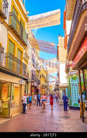 Siviglia, SPAGNA - 1 OTTOBRE 2019: La stretta e trafficata via dello shopping nel centro di Siviglia, con tende in cima, il 1° ottobre a Siviglia Foto Stock