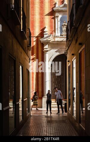 Una strada stretta e scura con turisti a Málaga, Spagna, Europa Foto Stock