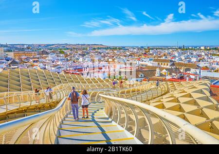 Siviglia, SPAGNA - 1 OTTOBRE 2019: I turisti camminano lungo il ponte pedonale di Metropol Parasol godendosi una vista incredibile sull'architettura circostante, 1 ottobre i Foto Stock