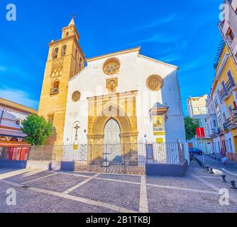 Siviglia, SPAGNA - 1 OTTOBRE 2019: La facciata della chiesa medievale Omnium Sanctorum con alto campanile, costruita in stile gotico-mudejar, 1 ottobre a Sev Foto Stock