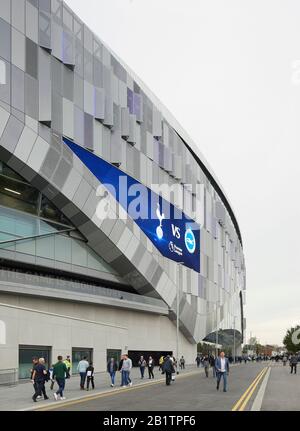 Prospettiva di facciata rivestita in acciaio e ventilatori in arrivo il giorno della partita. Il New Tottenham Hotspur Stadium, Londra, Regno Unito. Architetto: Popoloso, 2019. Foto Stock