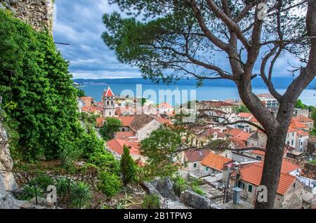 Veduta panoramica aerea della piccola città di Omis circondata da montagne, fiume Cetina e mare, riviera di Makarska, Croazia. Vista sulla pineta, città vecchia Foto Stock