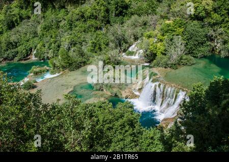 Vista dall'alto delle cascate nel Parco Nazionale di Krka, Croazia. Cascata di cascate circondata da foresta. Cascata di cascate circondata da foresta. Foto Stock