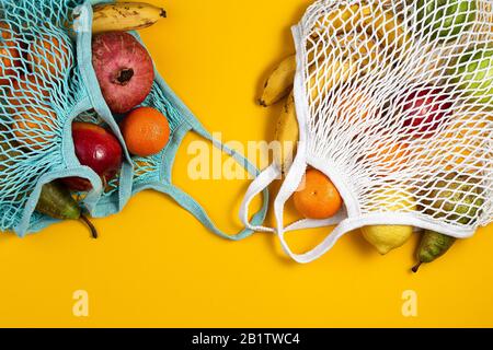 Concetto di assenza di rifiuti in plastica. Frutta fresca in un sacchetto di rete di maglia, vista dall'alto con copyspace. Borsa da shopping in mesh con frutta. Stile di vita sostenibile Foto Stock