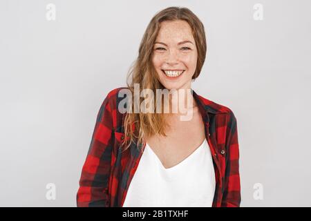 Stile Libero. Giovane donna con i temerari isolati su grigio ridendo allegro Foto Stock