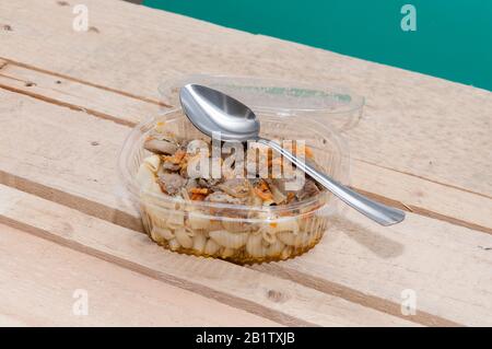 Fast food presso il cantiere. Alimenti in un contenitore di plastica Foto Stock