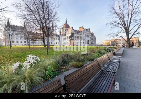 Palazzo del parlamento ungherese e parco da dietro in una giornata di sole nella stagione autunnale, vista angolata. Foto Stock