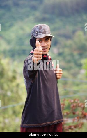 Lavoratore pollice in Puncak tea campo, Java, Indonesia. Puncak (che significa picco) è una città di montagna vicino a Giacarta e famosa per la cultura del tè. Foto Stock